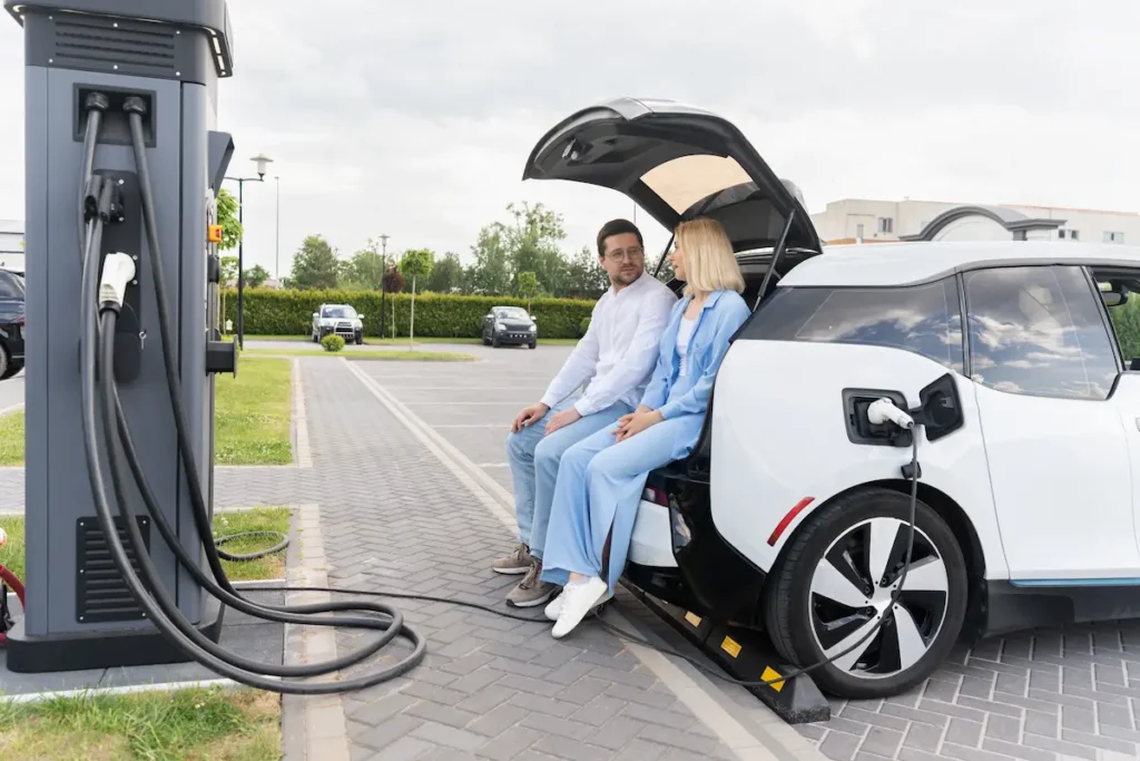 pareja sentada en el maletero del vehiculo how much does it cost to recharge the electric car